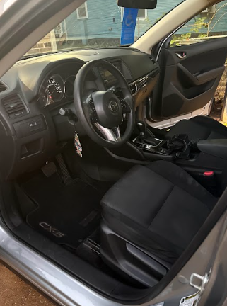 Mazda CX-5 cabin with the door open showing seats and floor mats