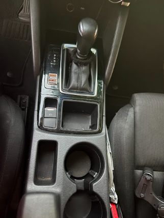 Close-up of a cleaned gear shifter, cup holders and center console